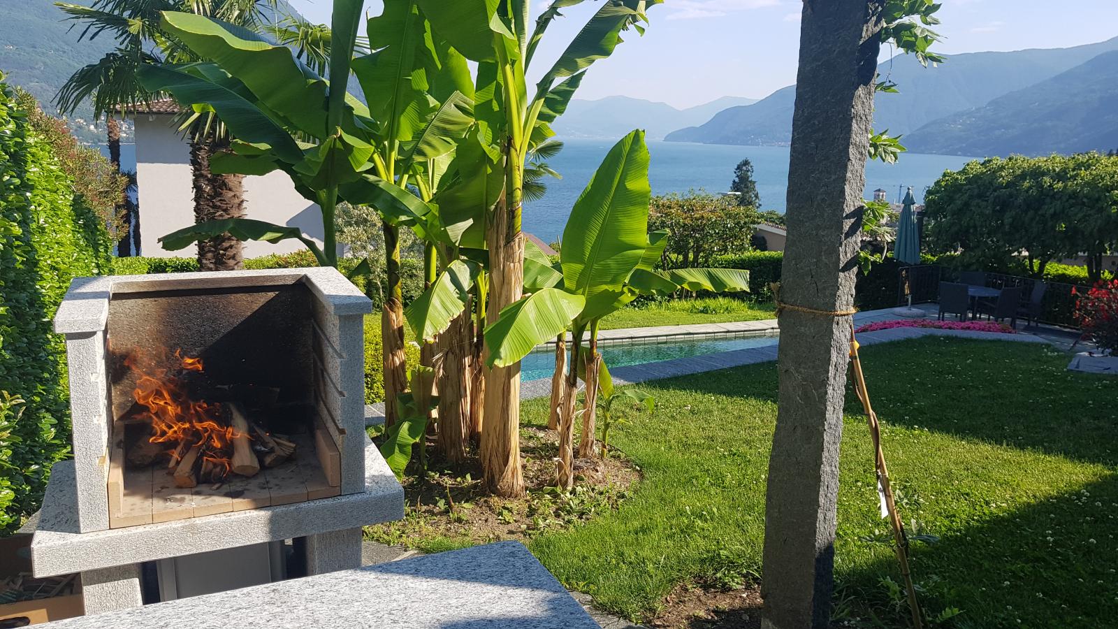 Von einem erhöhten Sitzplatz aus bietet sich ein beeindruckender Anblick auf den Grill und dahinter erstreckt sich der majestätische Lago Maggiore. Hier gelingt jede Grillade