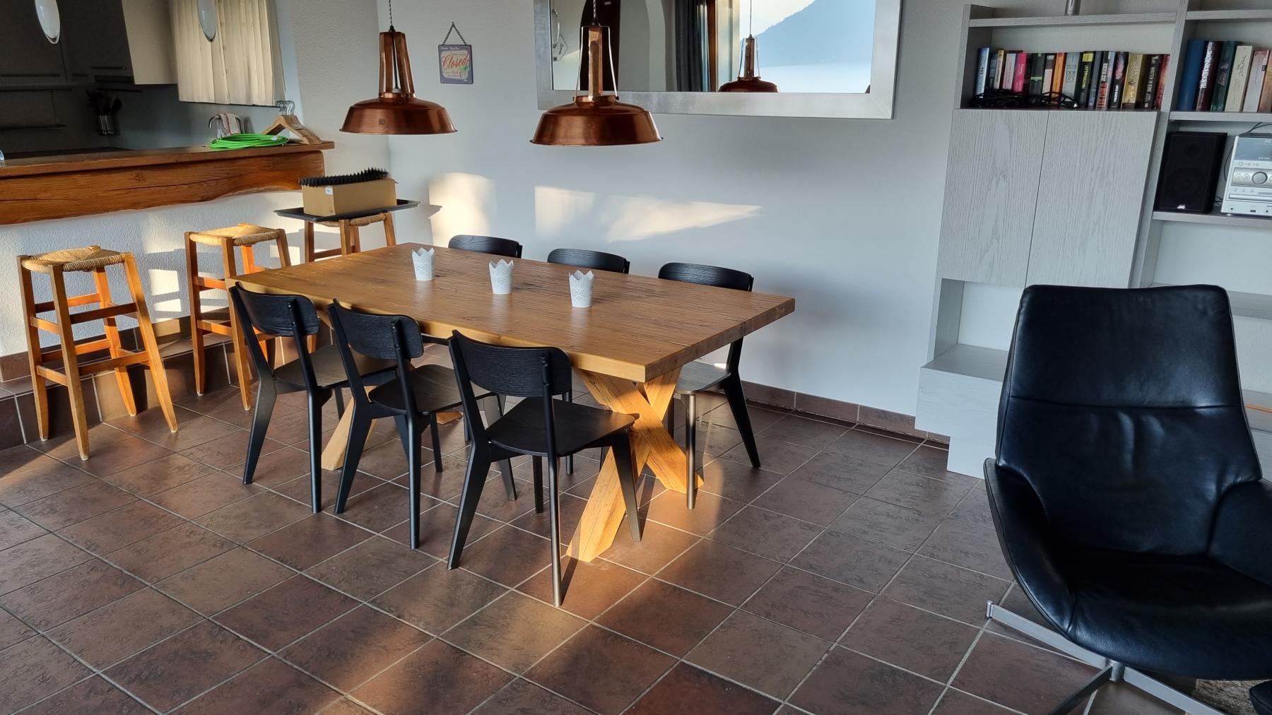 Der Essbereich im Casa Ramerino ist durch den grossen Eichentisch und die beiden kupferfarbenen Lampen rustikal eingerichtet. Bild zeigt den Esstisch und die Lampen