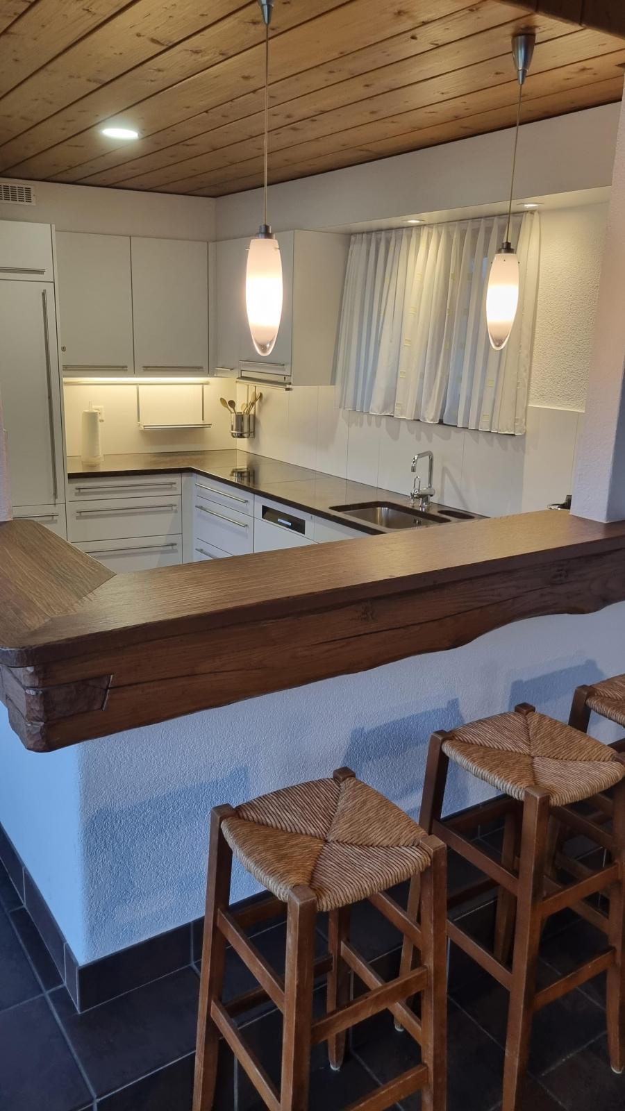 Die Küche im Casa Ramerino an der Via Riasco 28 ist nicht nur zum Kochen da, sondern auch zum Geniessen. Das Bild zeigt die Ansicht vom Wohnraum in die Küche, mittig ist die Bar