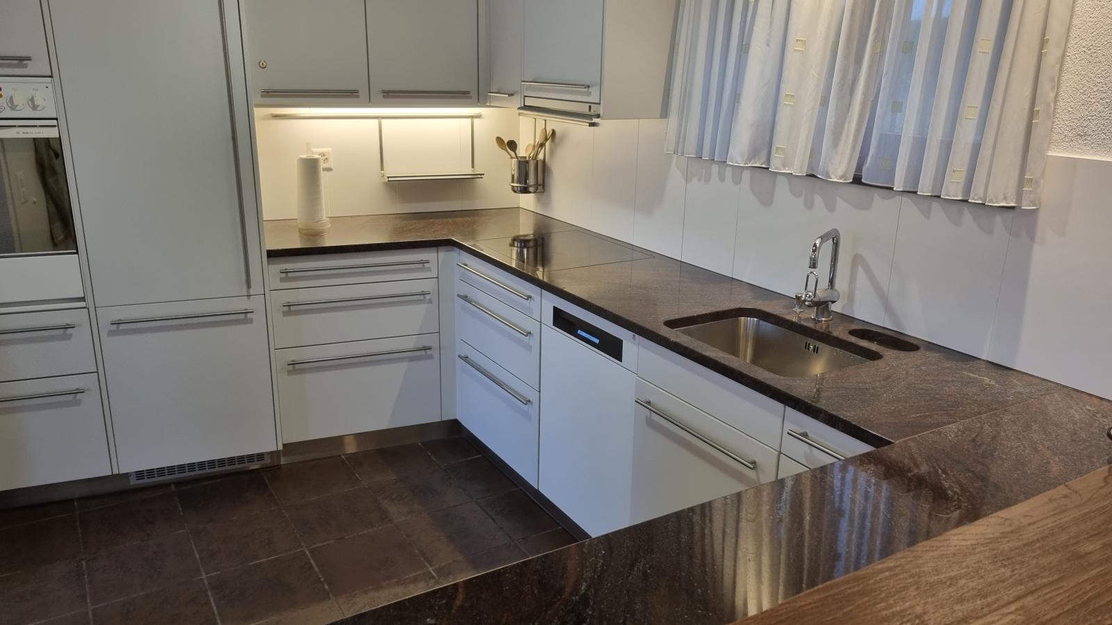 Die Küche im Casa Ramerino in Brissago ist grosszügig und mit allen notwendigen Geräten ausgestattet. Bild vom Wohnzimmer in die Küche